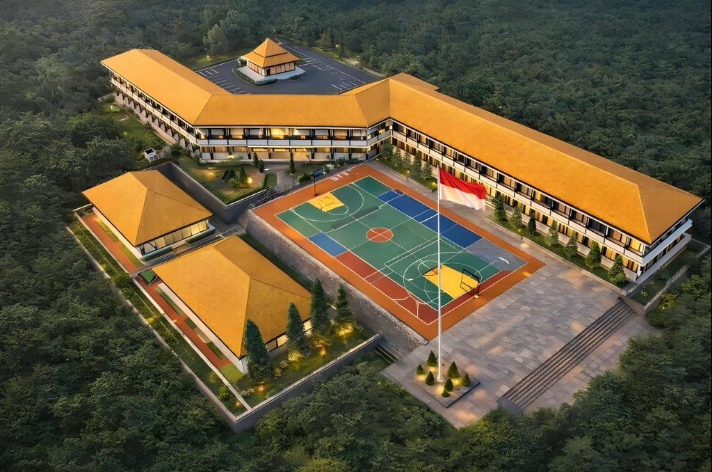 Aerial view of Indonesian school with golden roofs, green sports court, and surrounding forest.